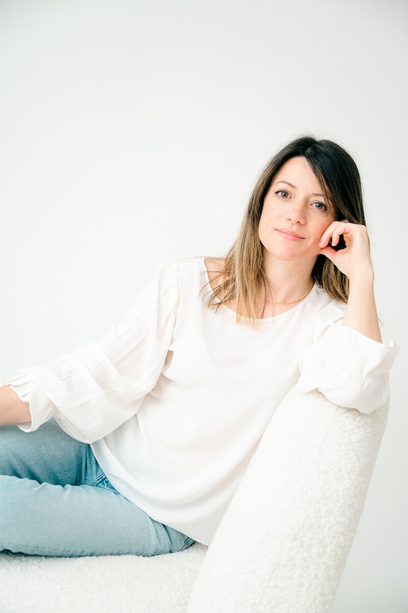 Portrait of Laura Mariani  sitting in a white boucle chair