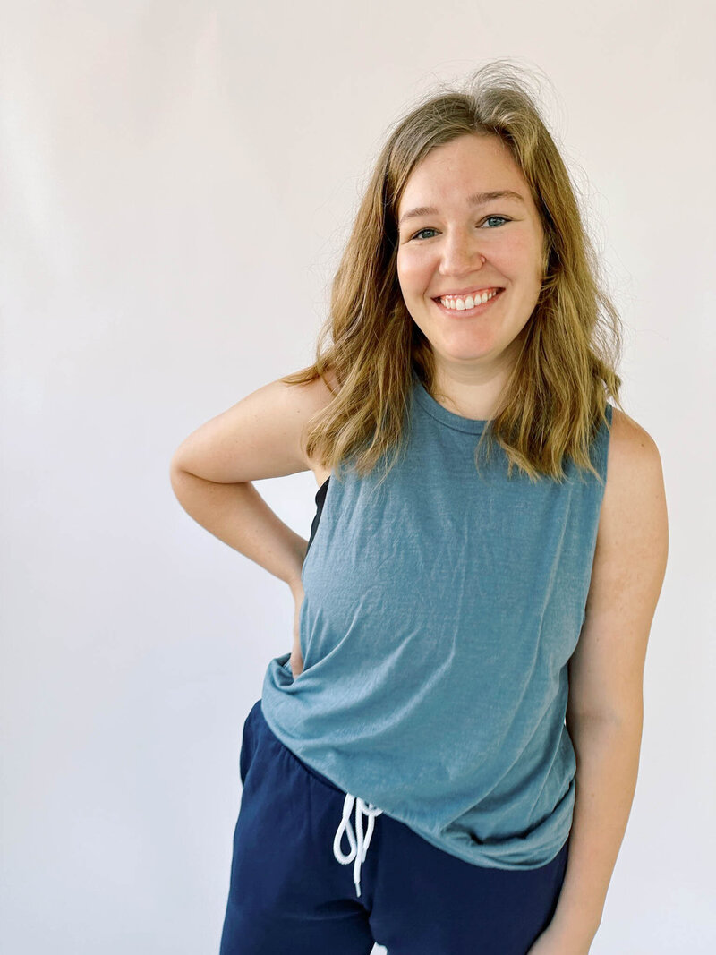 Woman wearing blue muscle tank tucked into navy joggers