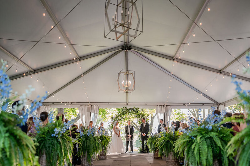 Bride and groom get married under at tent at the Skokie Country Club in Glencoe, IL