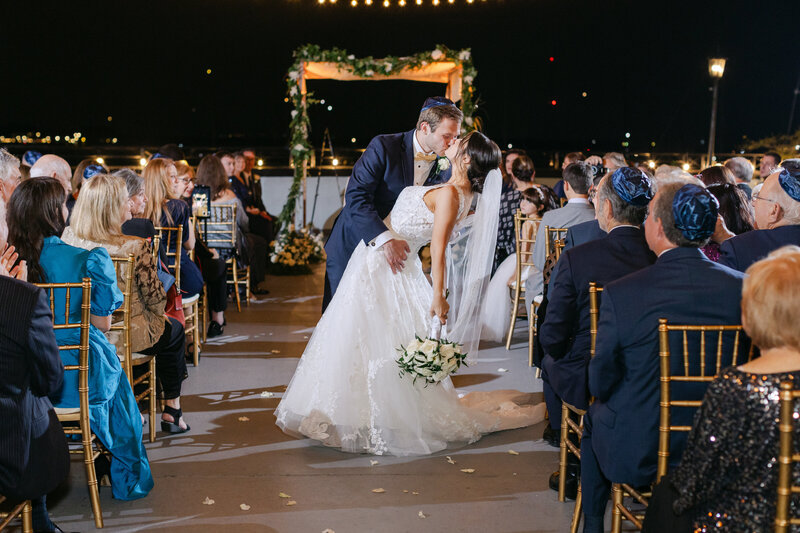 bride and groom running into sunset