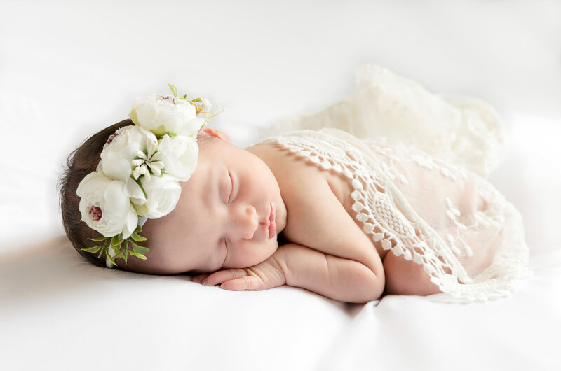 Newborn baby girl with white headband