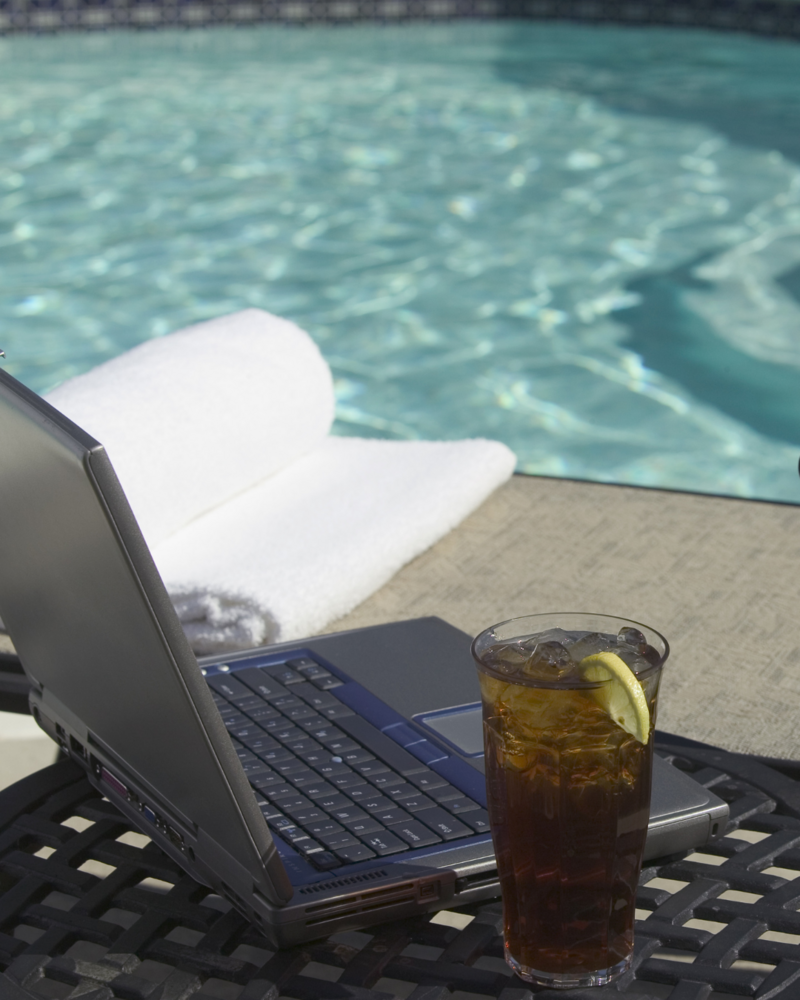 Laptop poolside for travel agent email marketing.