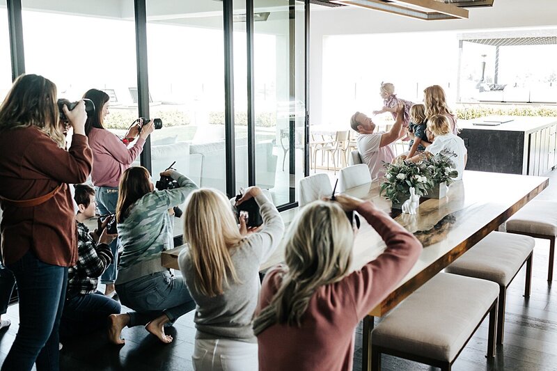 group of female photographers photographing a family in home at a retreat