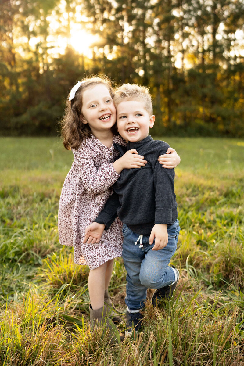 Brother and sister smiling off camera by Atlanta newborn photographer