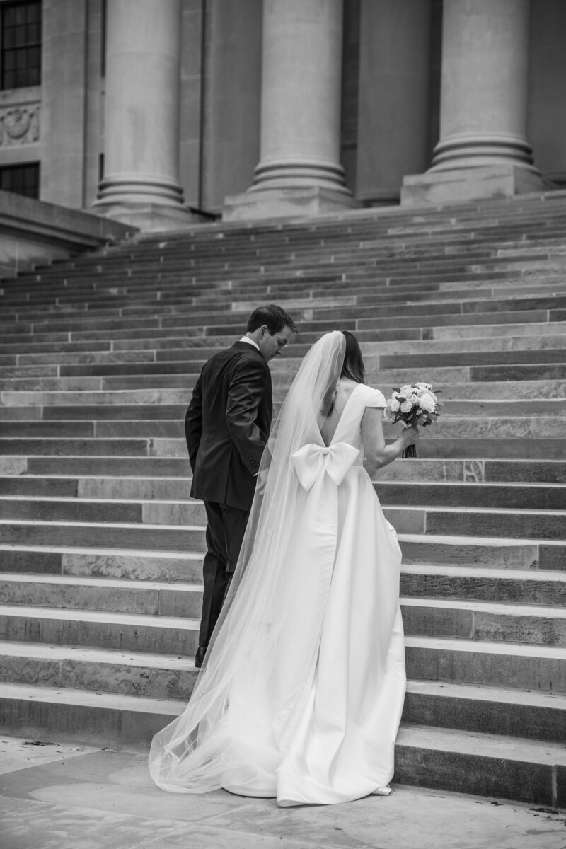 A bride and groom walking up the stairs at the Charleston, West Virginia State Captial.