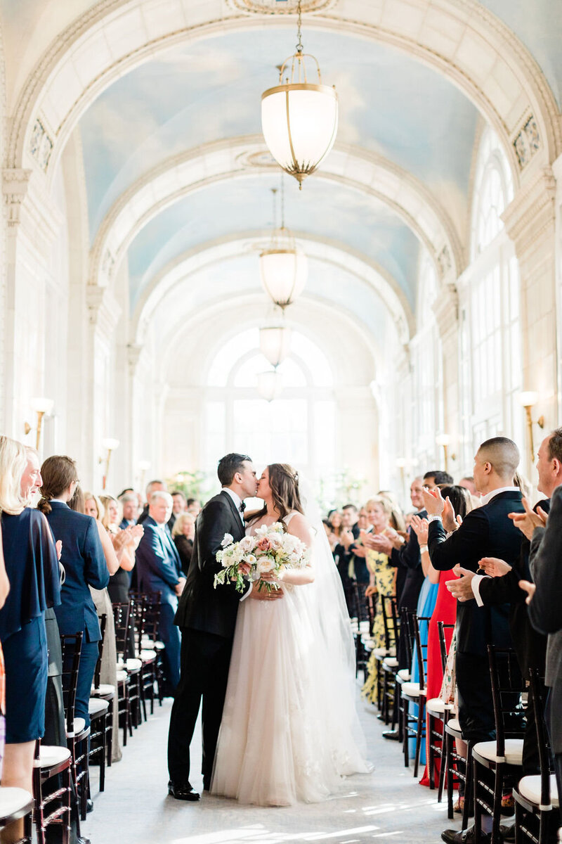 Bride and groom kiss in ceremony aisle at the Hermitage Hotel Nashville