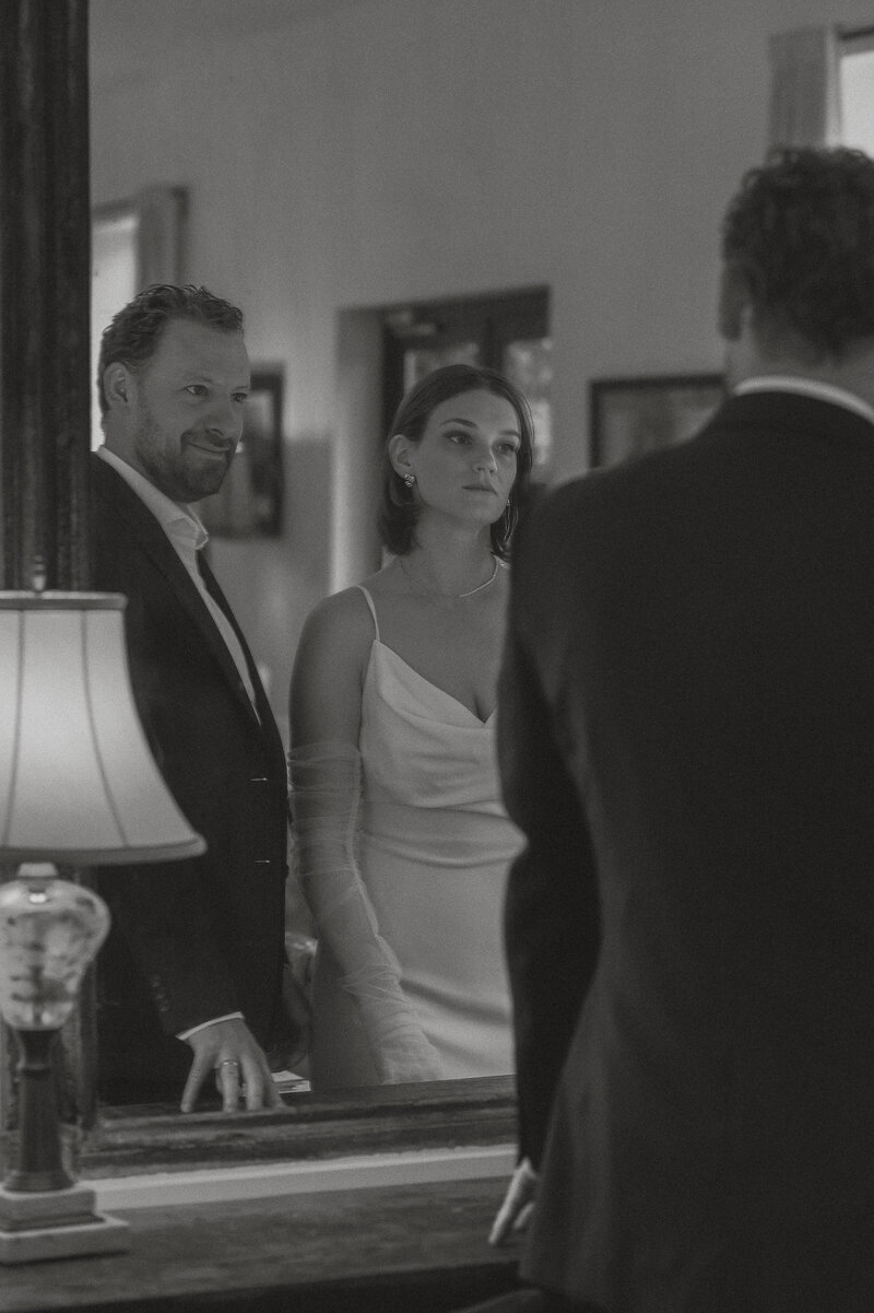 Bride and groom looking in the mirror at Cuckoo Trattoria in Coombs by latitude 49 photography