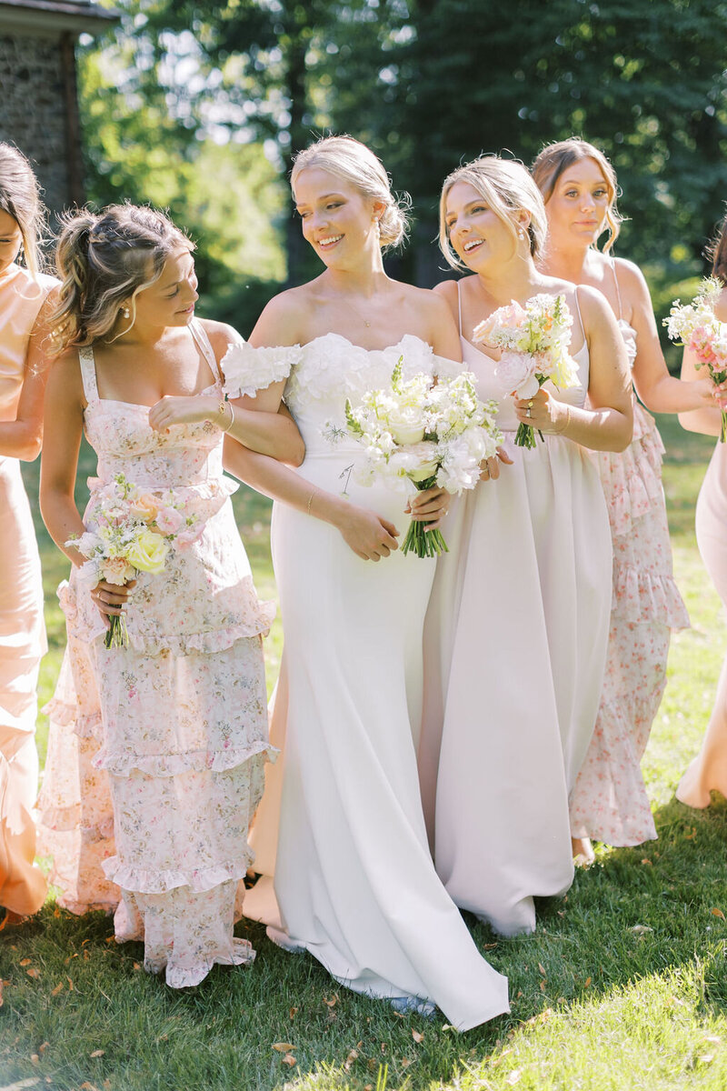 Bride walks with bridesmaids outside wedding venue