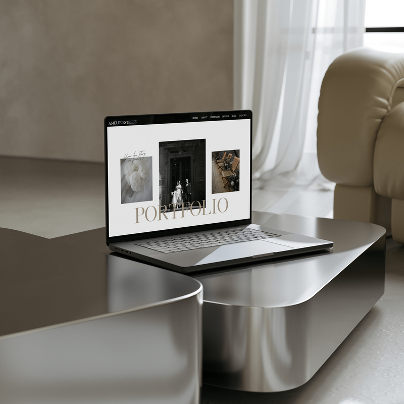 Laptop open on desk with photographer website