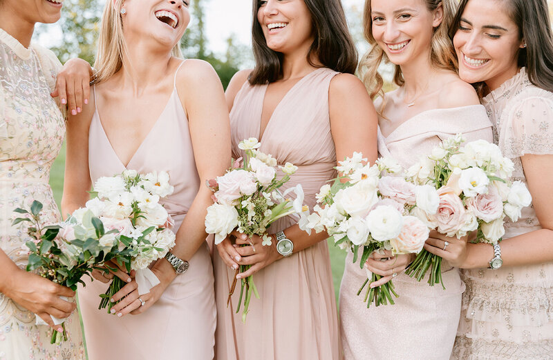 Bridesmaids laughing and holding their bouquets