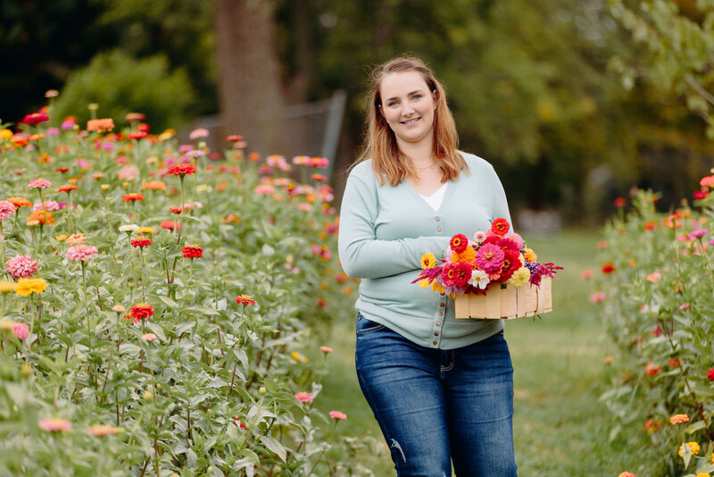 Emily outside filling a wooden basket with colorful flowers