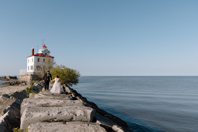Couple walking on the rocks at the Headlands Beach State Park lighthouse.