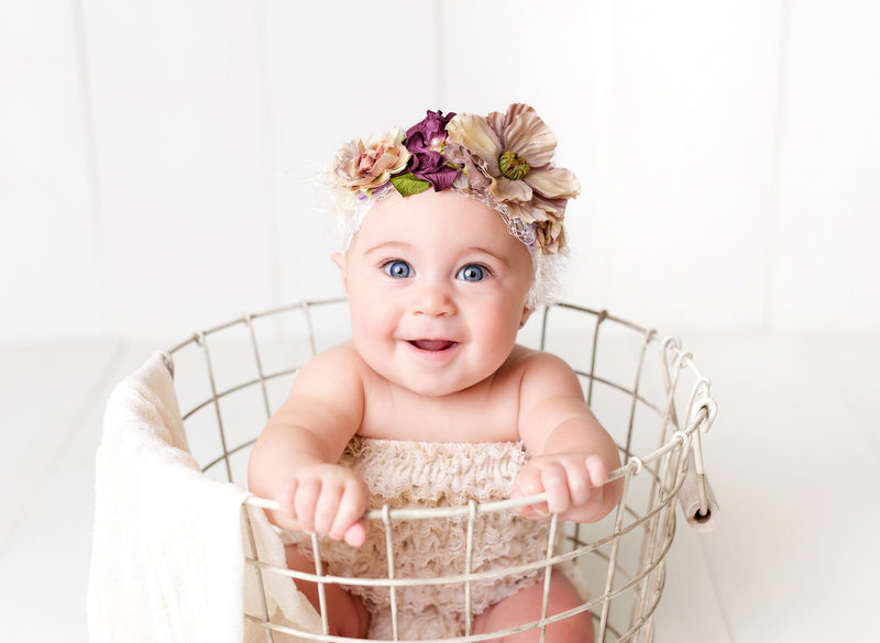 baby in a basket with headband