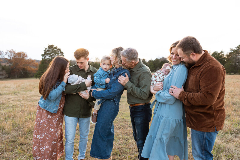 Extended family portrait session taken on the family farm with cows in the field in De Soto, Missouri. 