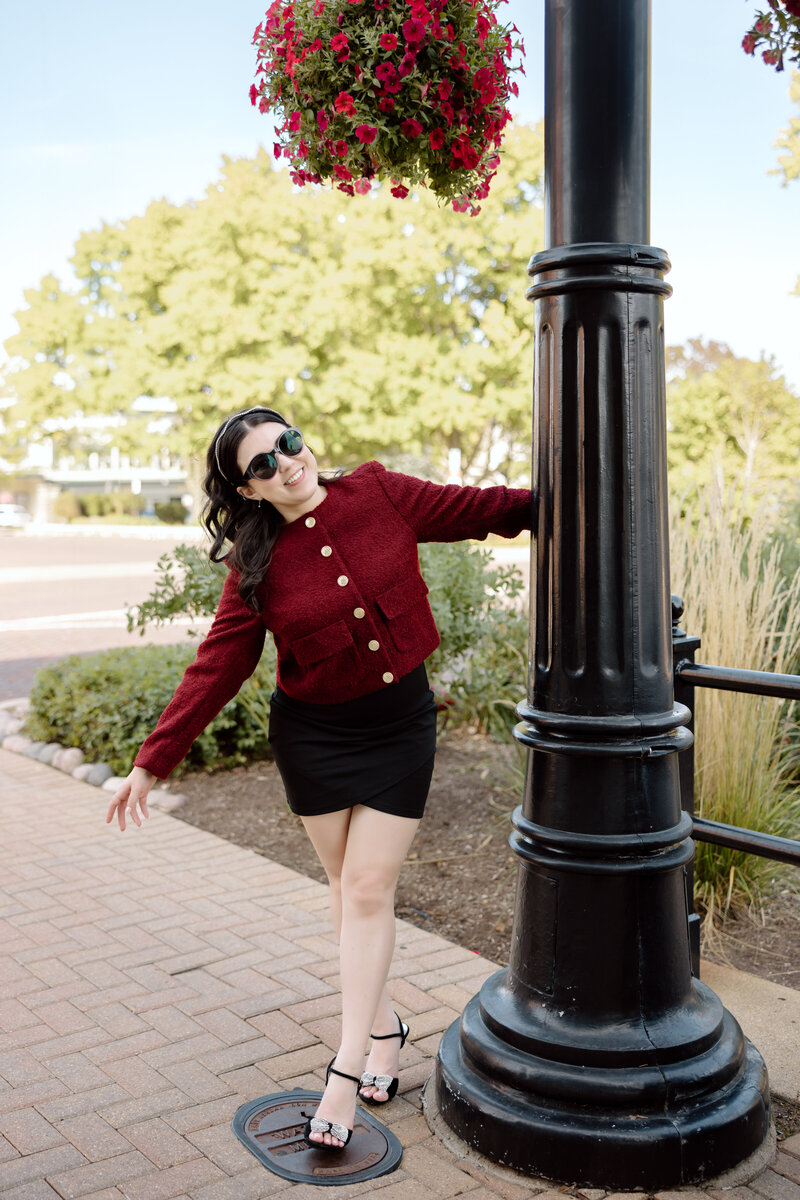 Shanté Gorman, host of Social Media Manager Confidential, leans playfully against a lamppost outdoors. A glimpse into the podcast host’s personality, sharing insights for social media managers.