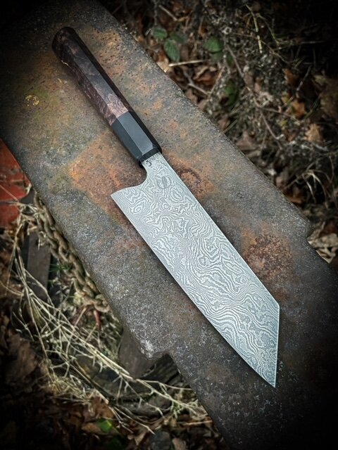 Chefs Japanese style knife on concrete in rough grass