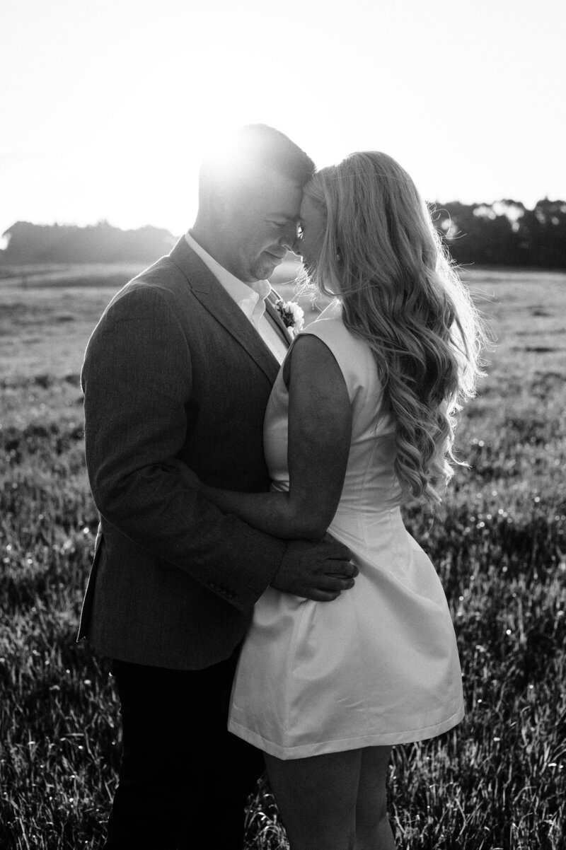 black and white photo of a bride and groom at sunset at the farm chapel waimumu