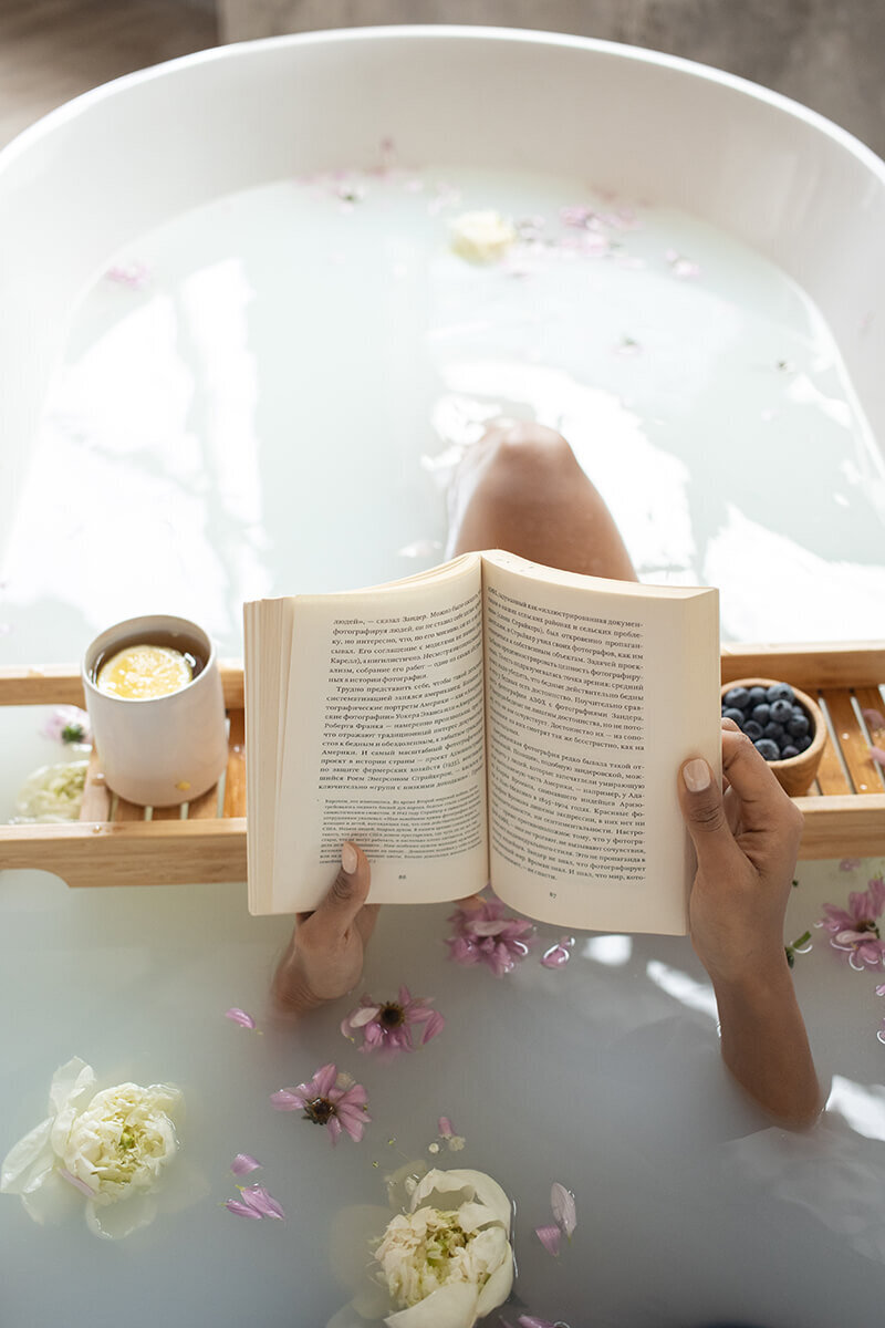 Woman reading a book while relaxing in a bath