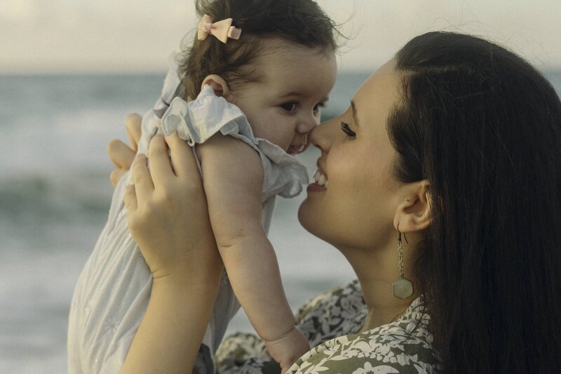 mother cuddles her baby on the beach