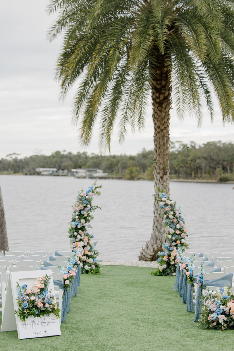 waterfront wedding aisle with floral arch by tampa wedding planner