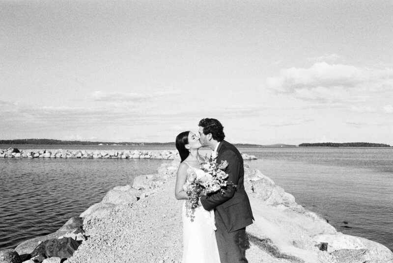 Bride and groom walking along shore at Halifax, Nova Scotia