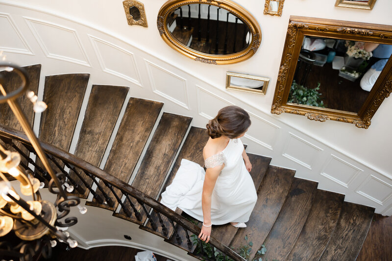photo looking down at bride as she walks down the stairs