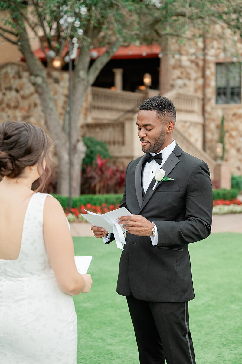 Groom reading his vows to a bride in a Italian inspired garden 