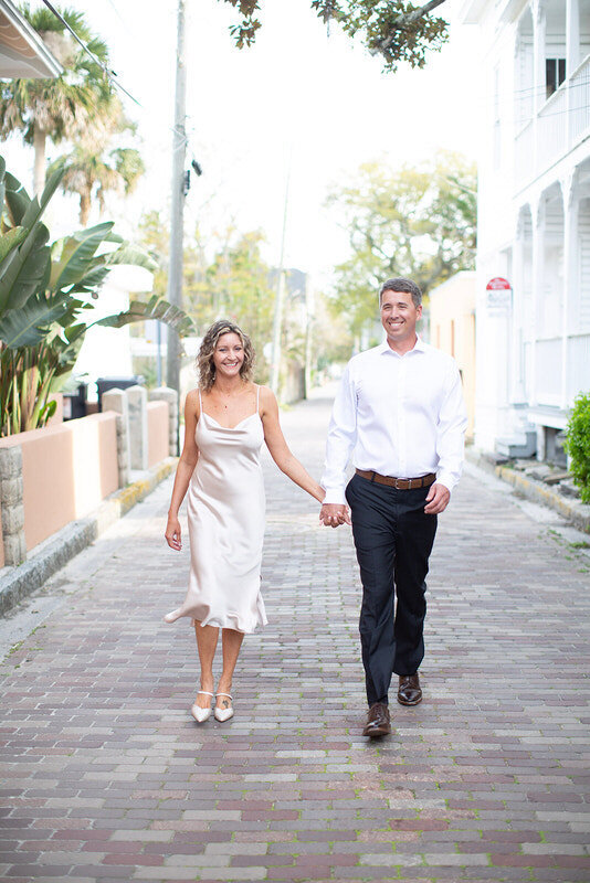 St Augustine engagement photo of a couple walking down a cobblestone street in downtown