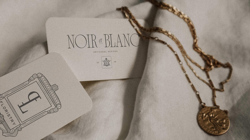 business cards and necklace on white sheet