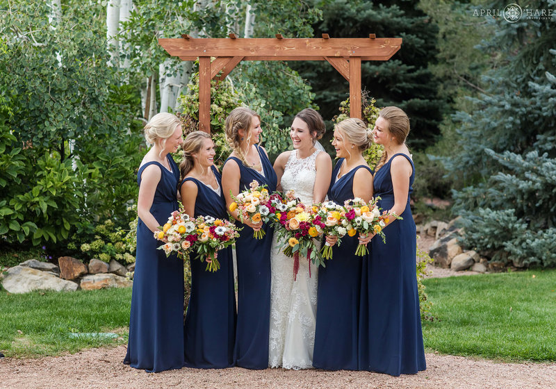 Bride with her bridesmaids wearing navy blue at Church Ranch Event Center