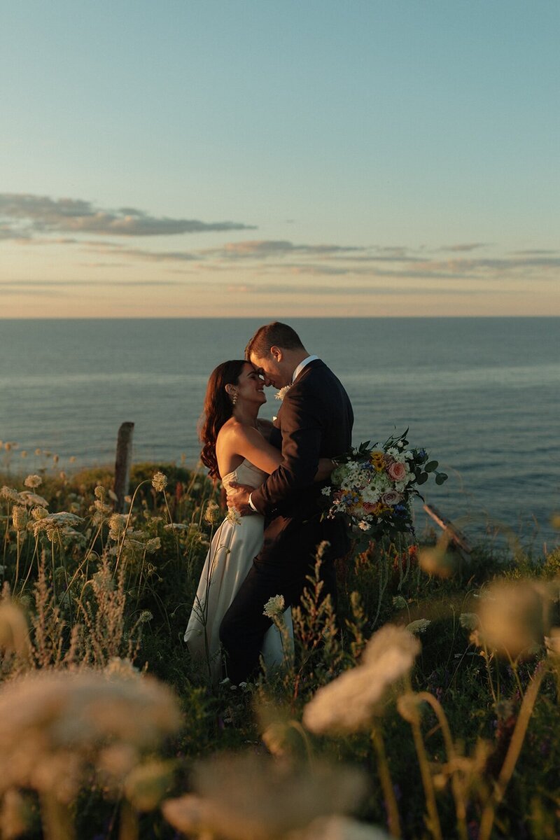 bride and groom embrace on beach at wedding in pei