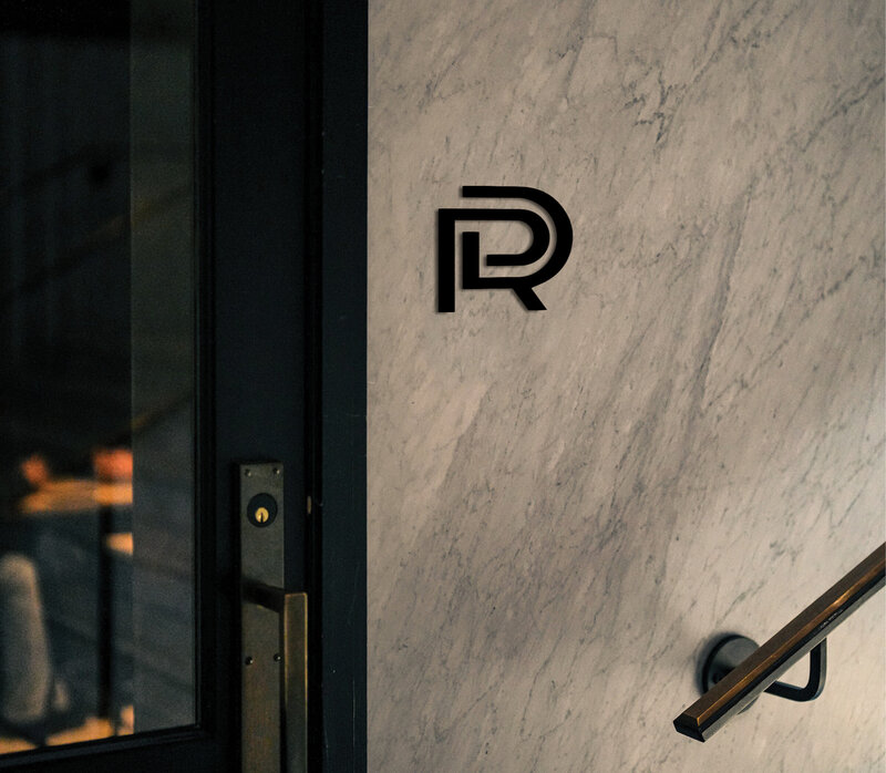 ReDesign logo displayed on a marble wall near a modern entrance, showcasing a sleek and contemporary brand identity.