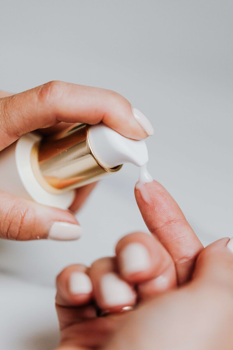 hands squeezing product from a skin care product onto fingers