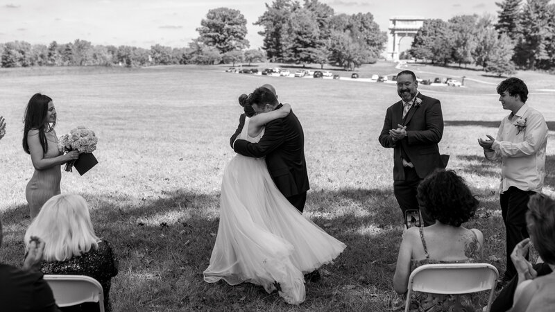 Black and white photo of a bride and groom hugging during their elopement ceremony in Valley Forge Park, capturing a heartfelt moment.