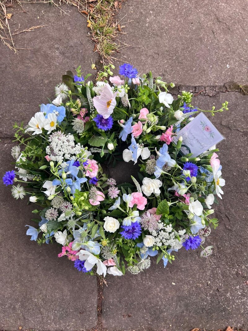 Round wreath of flowers for a funeral in blue and pink flowers