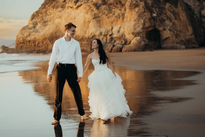 a bride walking on the beach with her husband