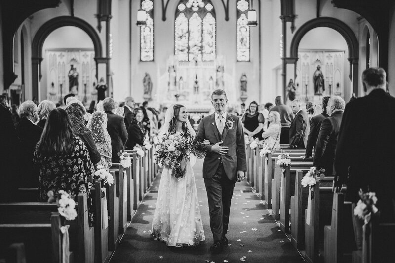 Catholic bride and groom recess up aisle after their nuptial Mass in Rockford, IL.