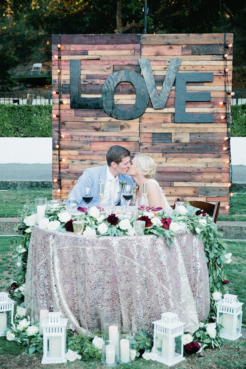 A joyful bride and groom dancing together during their reception, surrounded by friends and family.