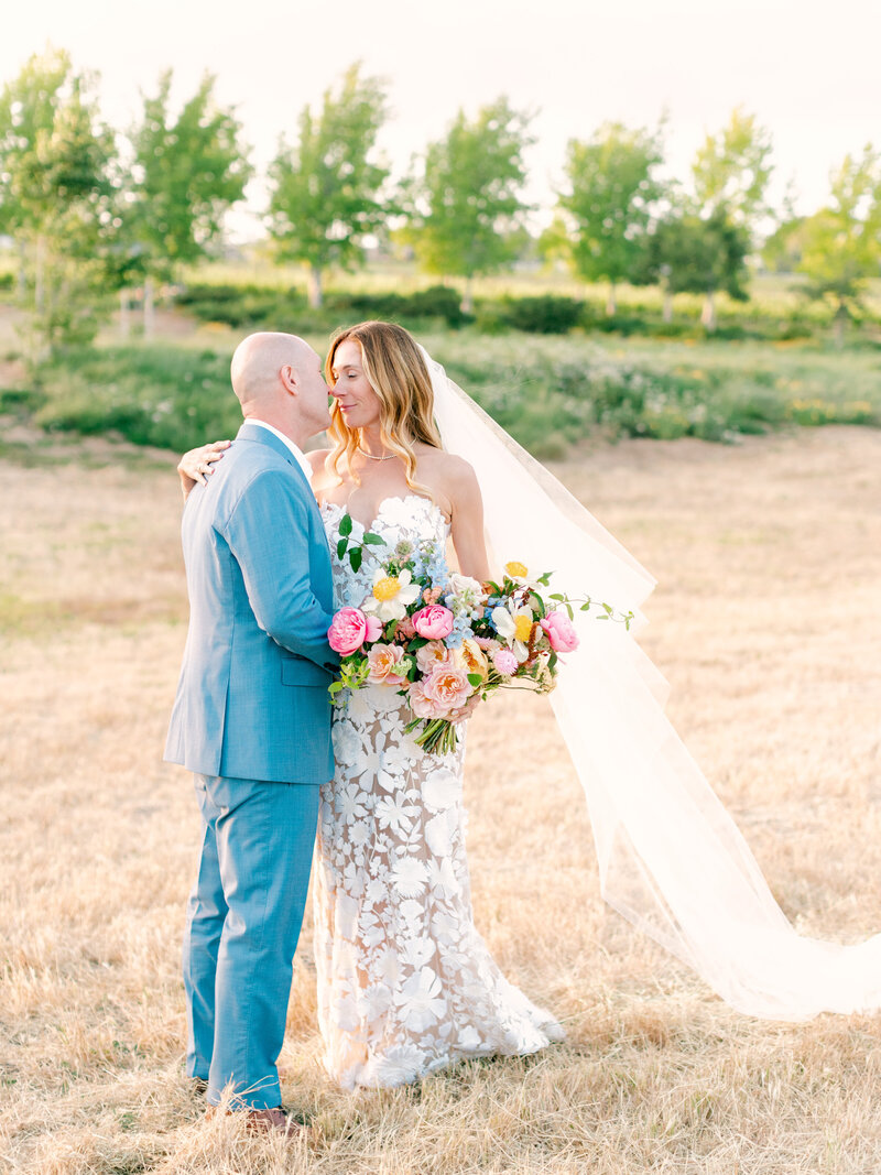 Stunning bride and groom embrace while holding bouquet at Brave & Maiden Estate