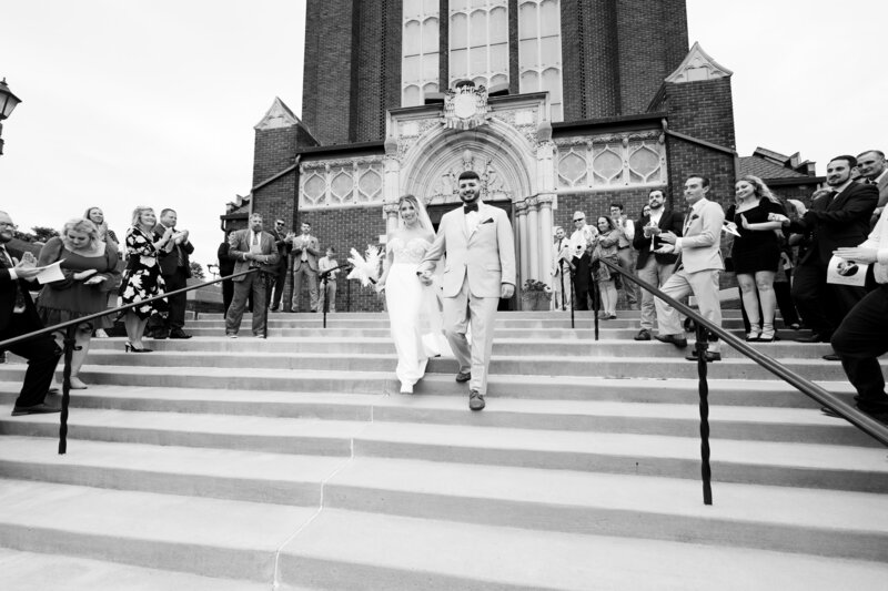 Groom leads his bride down the stairs at St. Patrick's Church in Youngstown, Ohio. Photographed by Aaron Aldhizer