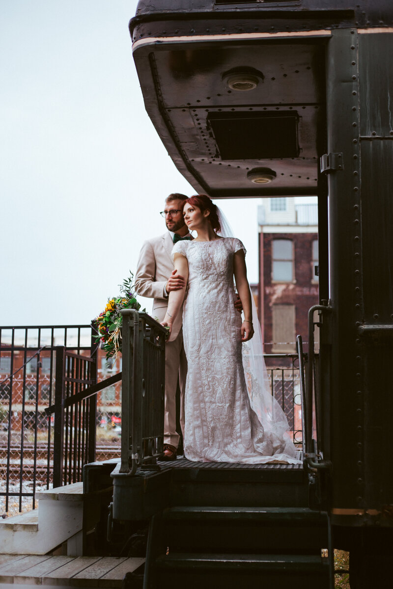 bride and groom standing on back of train