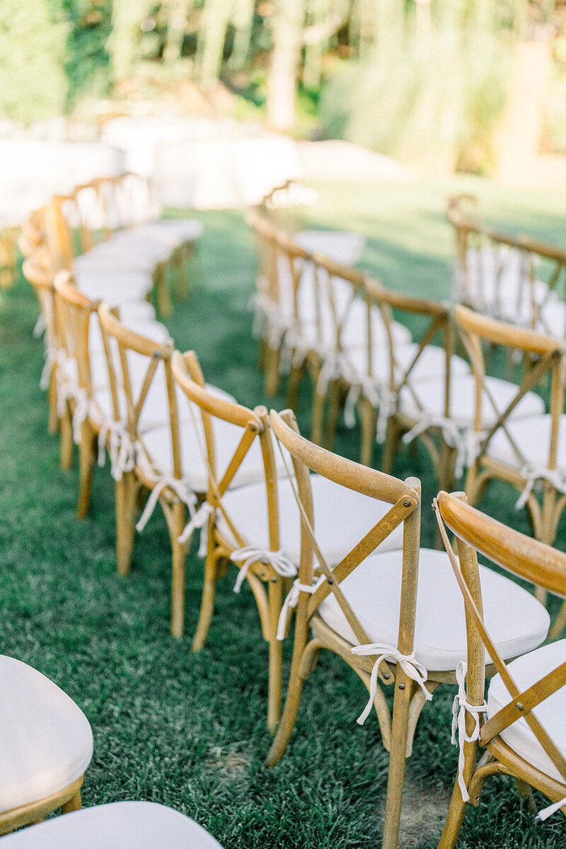 Tiffany Longeway Photography captures the serene and elegant ceremony setup at Chalk Hill Estate Vineyards & Winery in Healdsburg, California. The beautifully arranged wooden chairs and lush green surroundings create an intimate and picturesque setting, ideal for couples seeking a natural and sophisticated venue for their wedding celebration.
