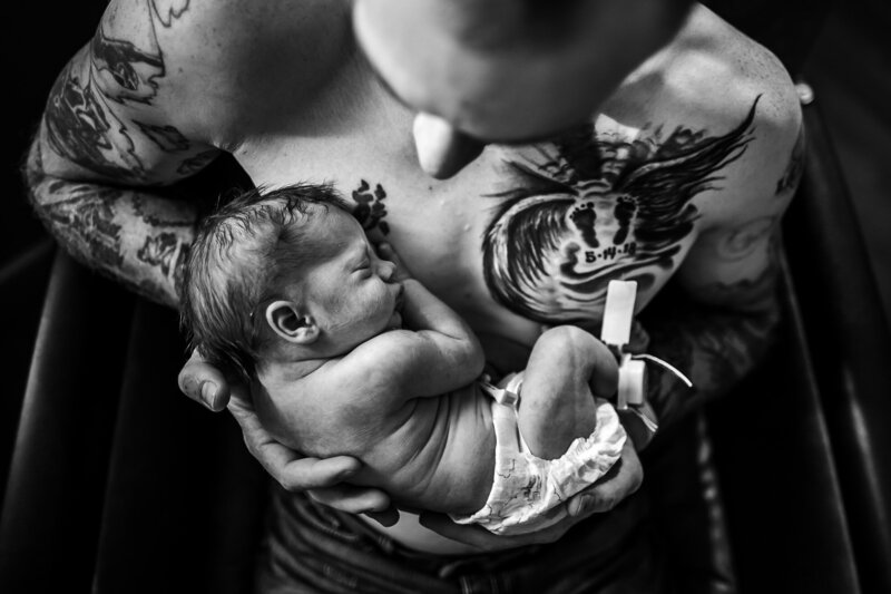 A new dad holds his son after a rainbow birth in Billings Montana Montana Doula, Birth Photographer & Birth Advocate