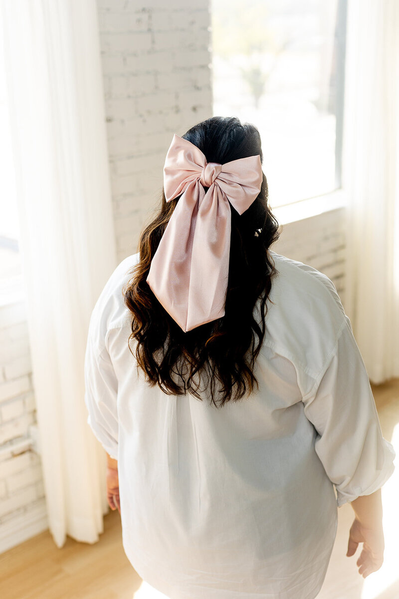 The back of Marissa Martinez's hair with a big pink bow in it