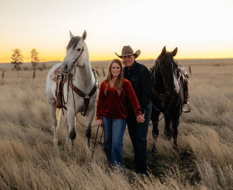 Couple posing in Nebraska's scenic outdoors, with the man wearing a western hat, capturing a rustic and romantic vibe against the beautiful natural landscape.