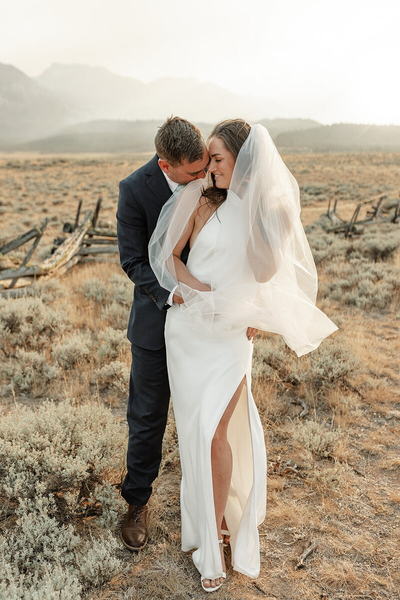 Photo of a bride and groom standing in the desert at golden hour