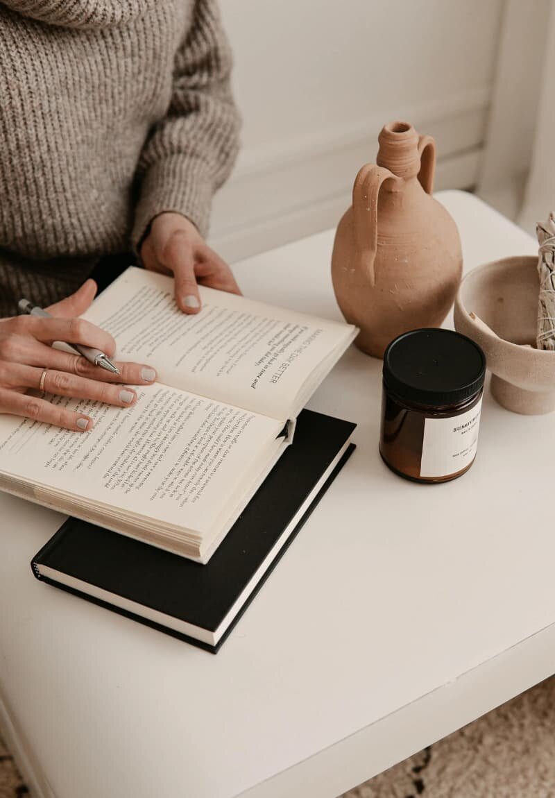 Woman writing in a book, representing uncovering the real story behind a brand to engage and connect audiences.