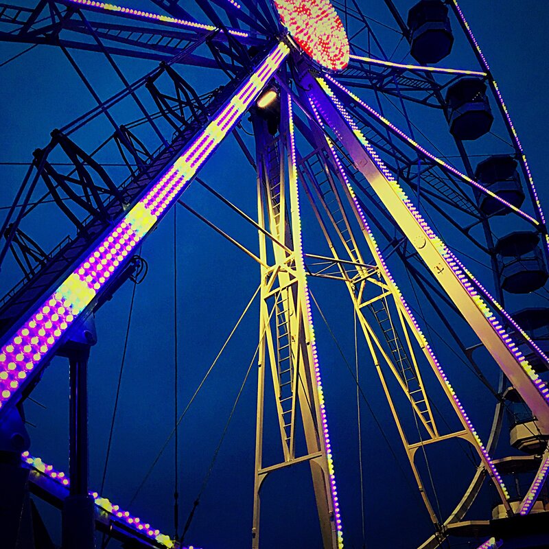 low-angle-view-illuminated-ferris-wheel-against-blue-sky
