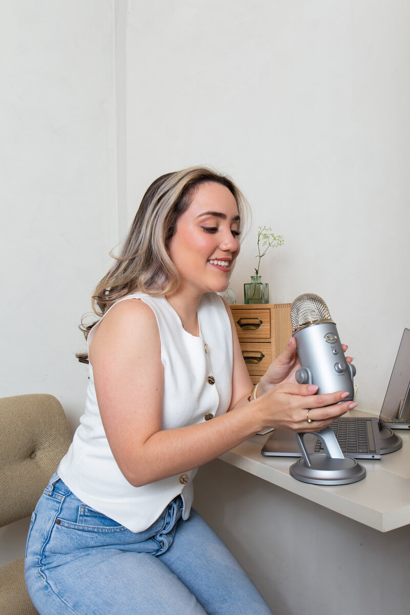 Merlyn Asencio speaking into her mic at her desk, actively connecting with clients and sharing her expertise in trauma therapy with a warm, approachable demeanor in Florida