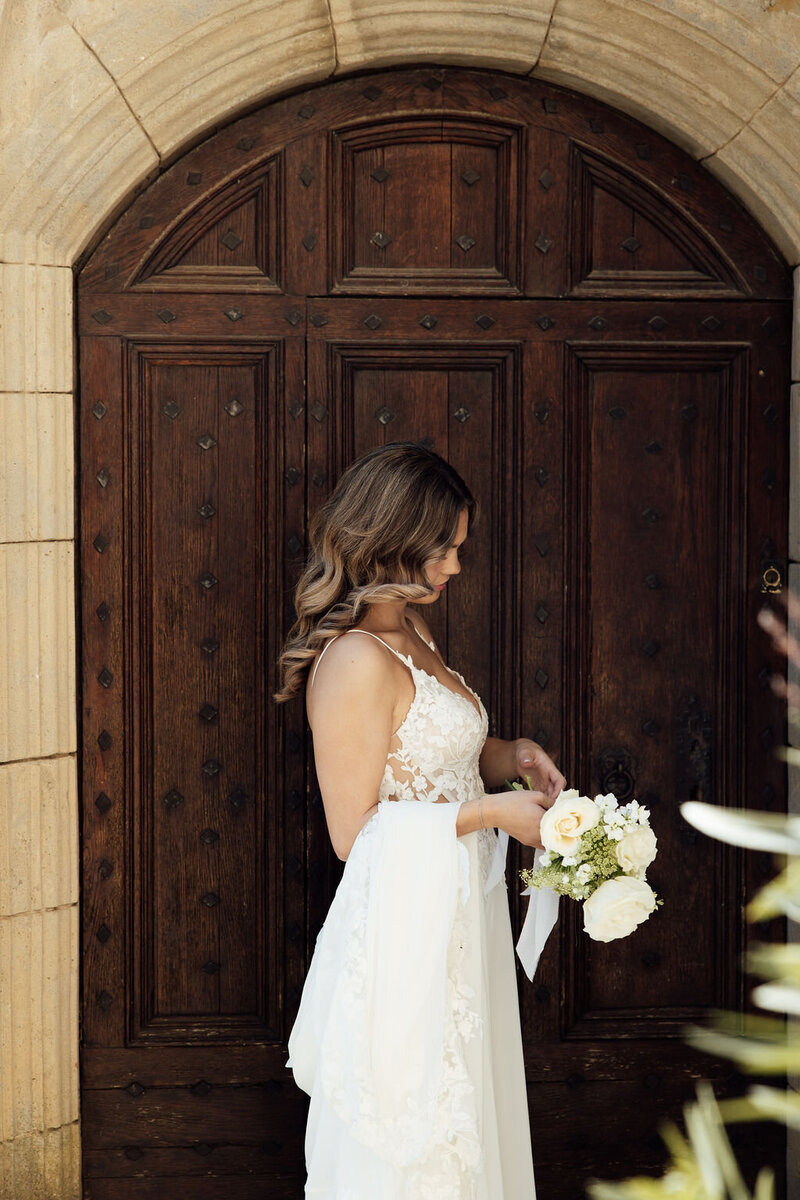 bride-standing-in-front-of-chateau-door